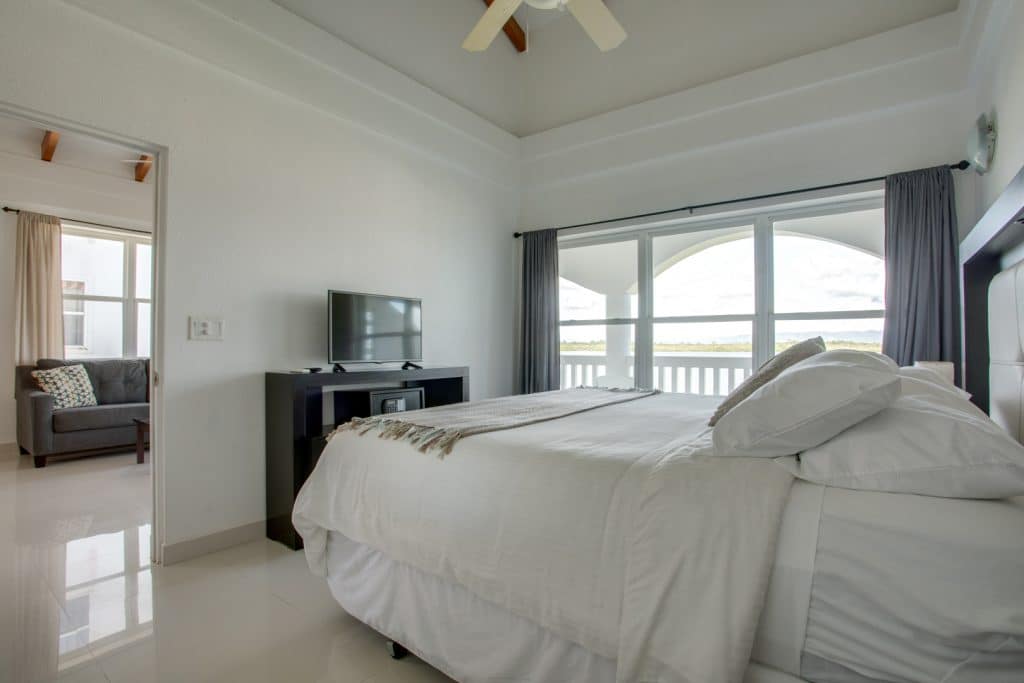 The master bedroom with a king sized bed and a television inside the 2 Bedroom Beachfront at Umaya Resort & Adventure