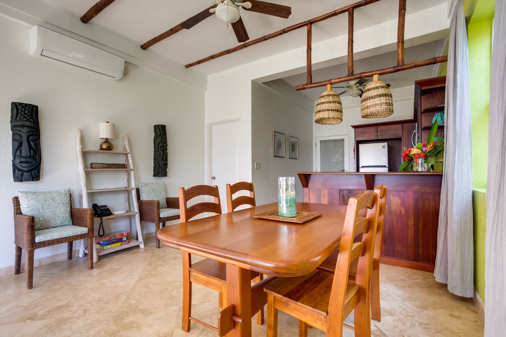 Dining room with a wooden dining table and four chairs inside the 1 Bedroom Lagoon Bayview at Umaya Resort & Adventure