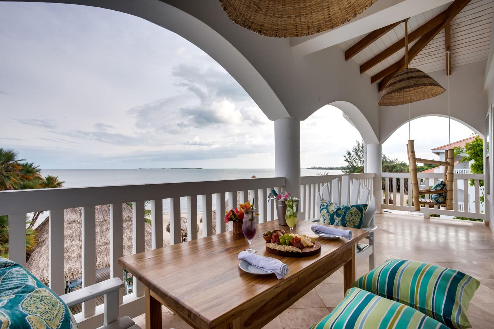 Balcony with a wooden table and chairs outside of the 1 Bedroom Beachfront at Umaya Resort & Adventure