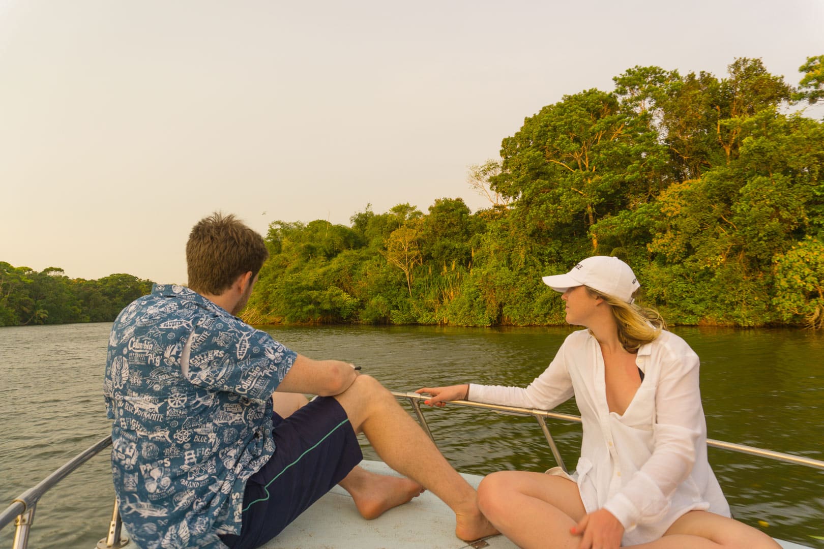 A couple sitting on the bow of the boat watching the river on the Sittee River Cruise and Wildlife Tour at The Lodge at Jaguar Reef