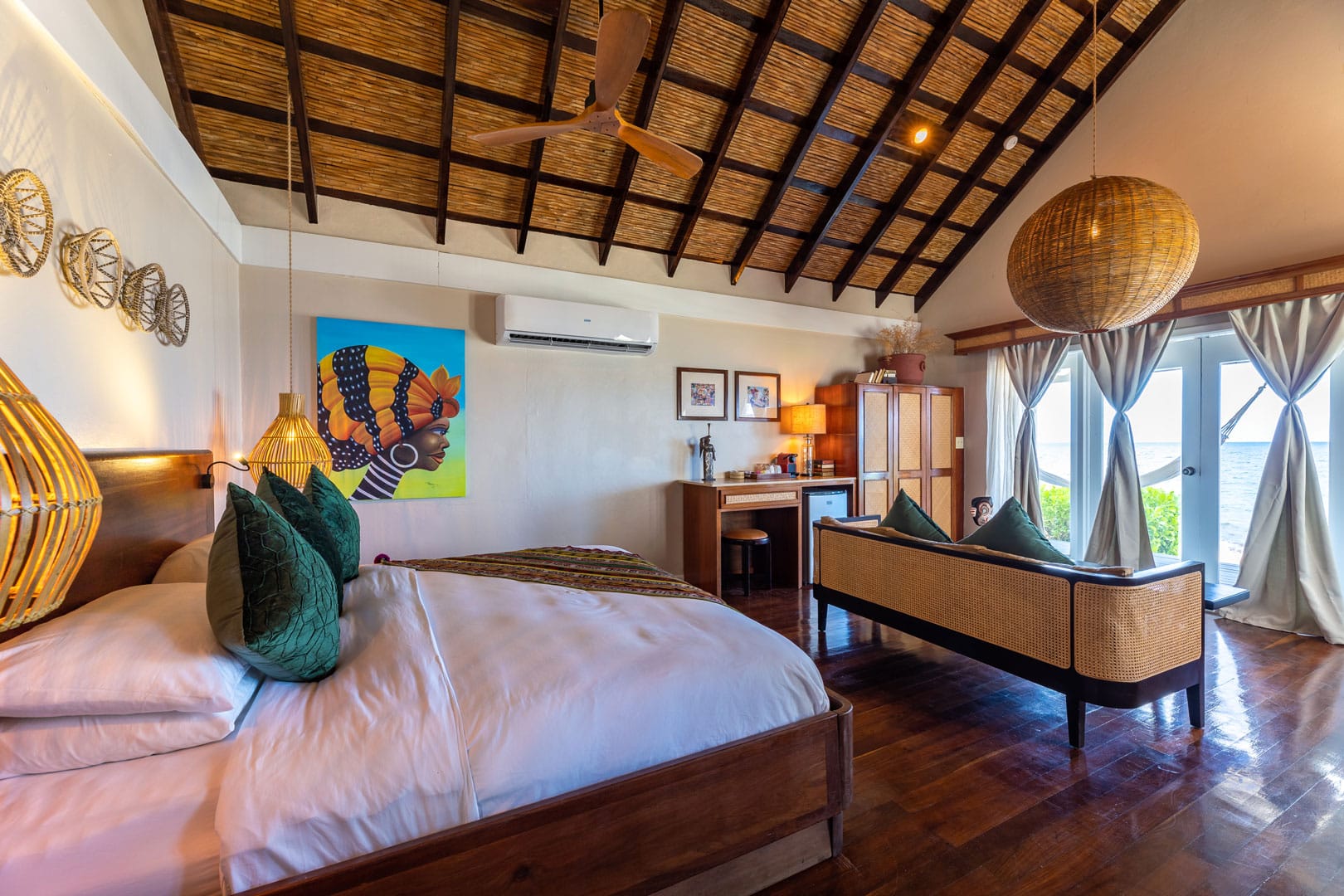 Side view of the queen sized bed with pillows and linen inside the Beachfront Cottages at The Resort at Almond Beach