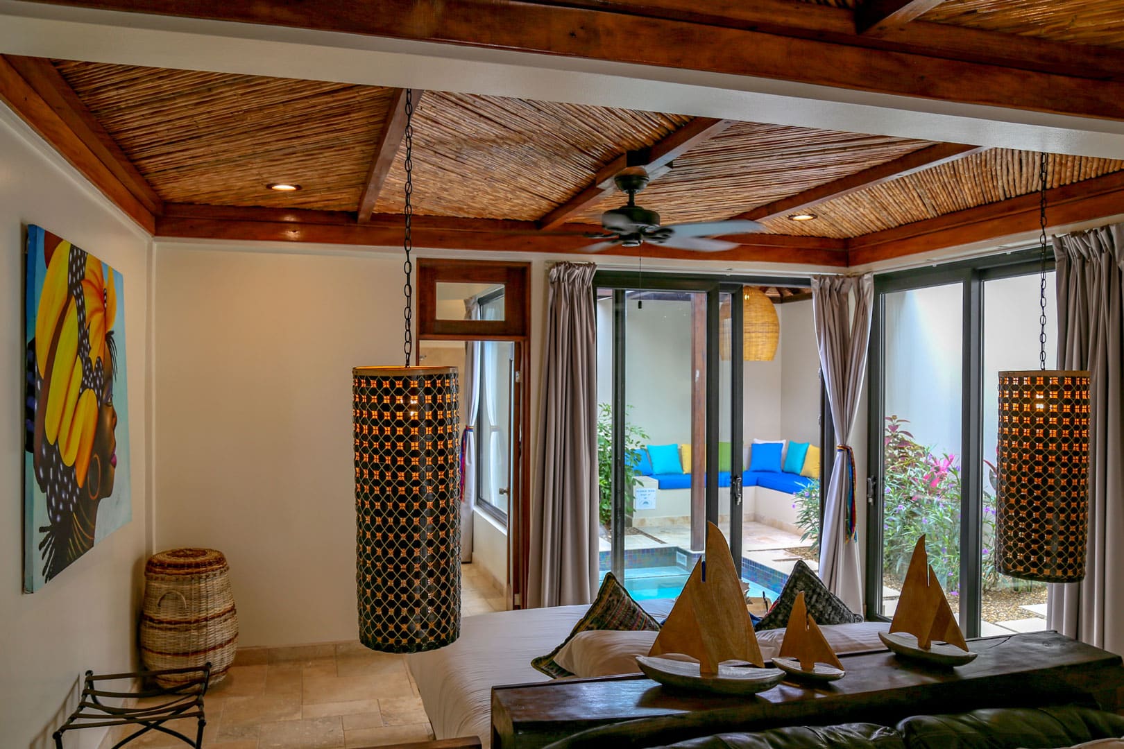 Corner view from the master bedroom looking out the glass doors to the patio and plunge pool inside the Deluxe Suites at The Resort at Almond Beach