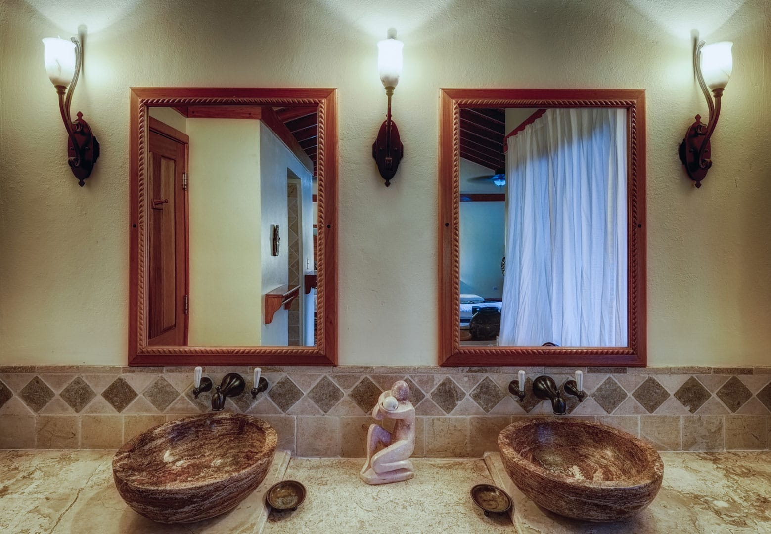 Large bathroom counter with two vanity mirrors and matching sinks inside the Seaview Deluxe Rooms at The Resort at Almond Beach