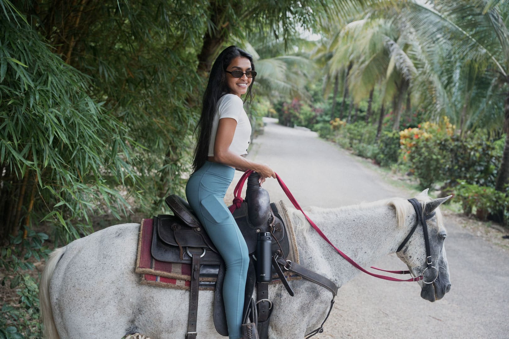 A guest on the back of white horse doing Horseback Riding at The Rainforest Lodge at Sleeping Giant Resort